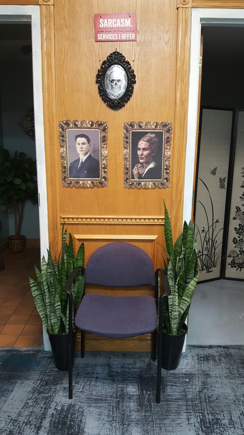 A wooden door hung with two gilt-framed vintage portraits, an ornate mirror and a small sign reading sarcasm, just one of the many services I offer.