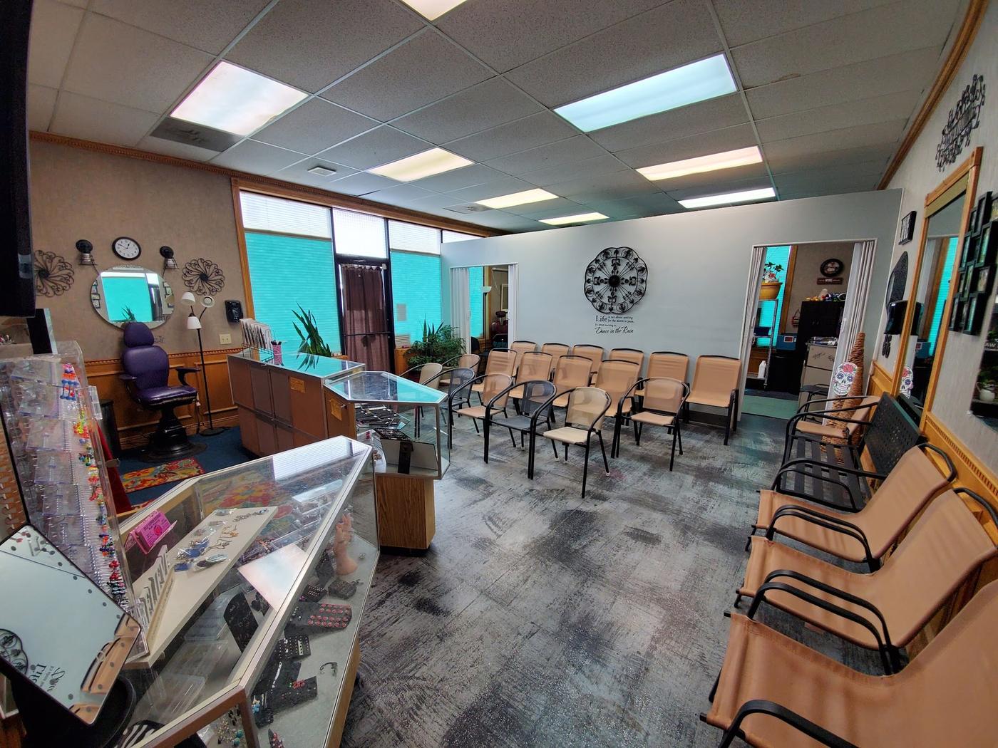 The front room at Self Expressions: rows of waiting chairs, glass jewelry cases along one wall and a piercing chair by the window.